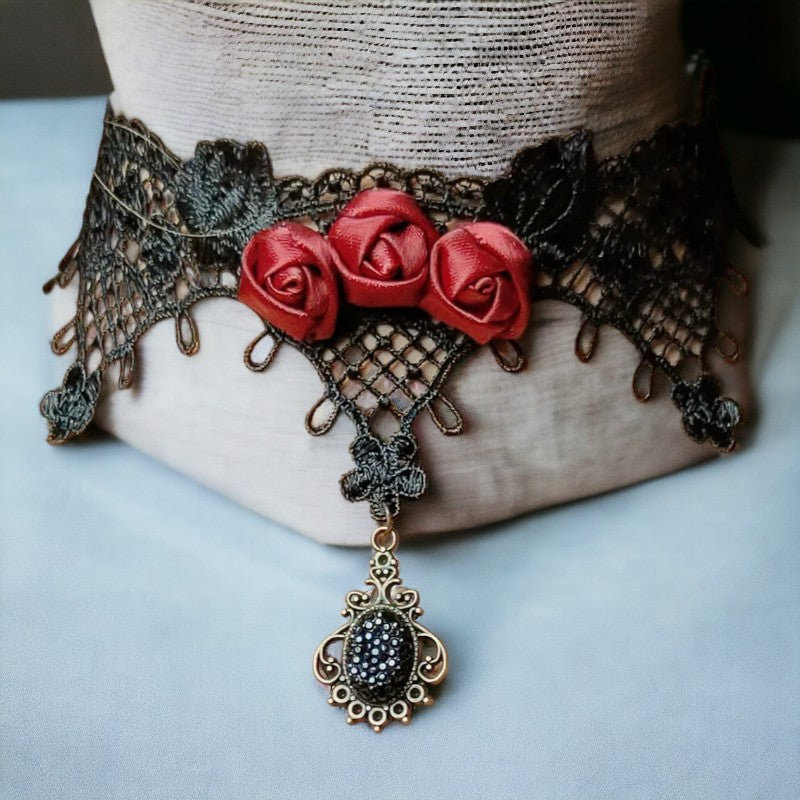 Zwarte kanten choker met 3 rode roosjes en amulet met glittersteen