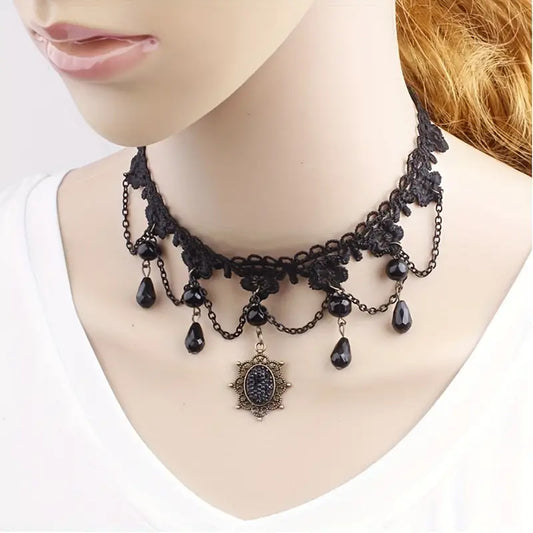 Zwarte kanten choker met ronde en langwerpige pareltjes en amulet met blingbling-steen