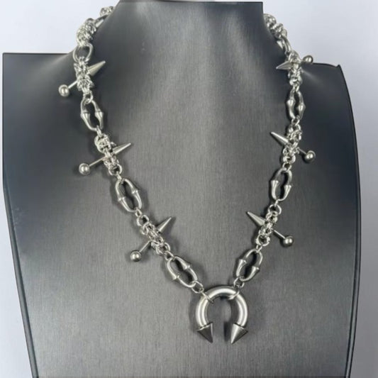 Halsketting met groffe halve cirkel en pinnen met bolletjes en studs
