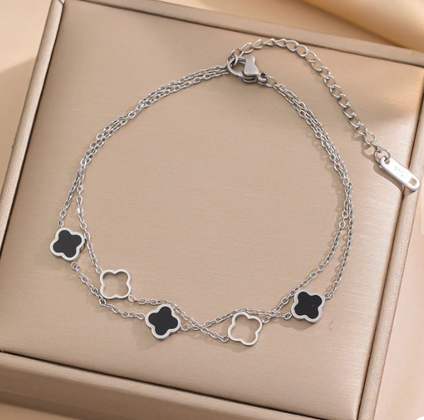 Dubbele fijne armband met zwarte klavertjes en doorzichtige