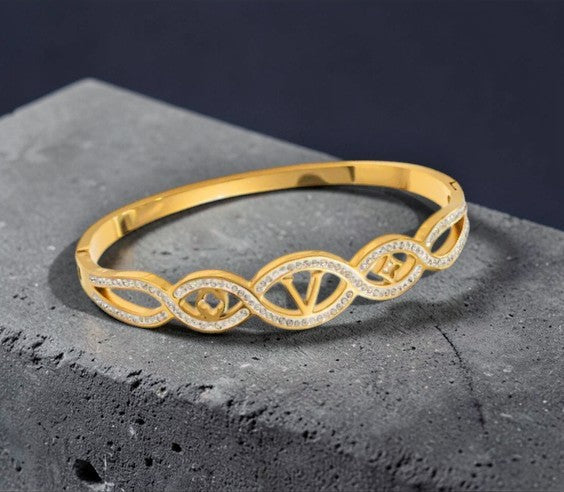 Stijve armband met letter V en klavertje en sterretje